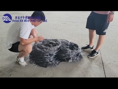 Un char de défense du champ de bataille avance à travers une grille de fil de fer